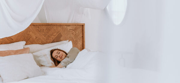 Vrouw slaapt diep en comfortabel in een koel bed dankzij CoolSleep KOZ-É bedkoeling.